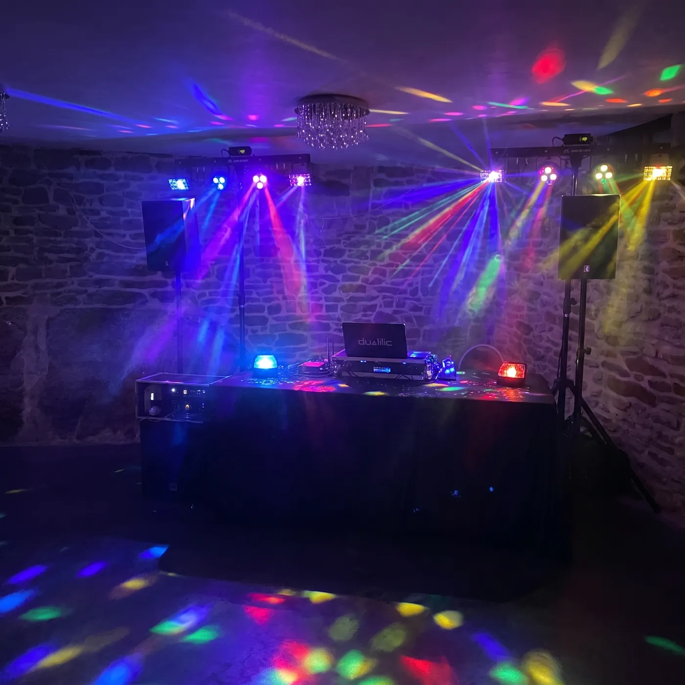 Compact DJ setup with dance-floor lights for a private party